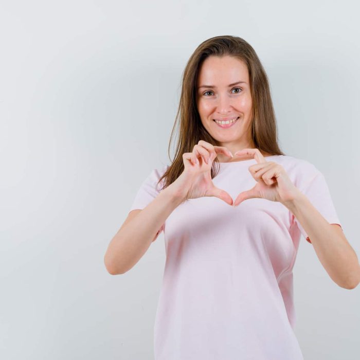 Noia fent símbol cor